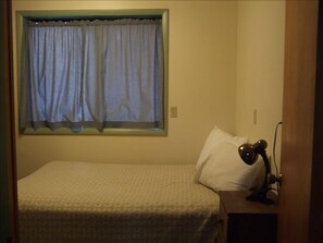 Downstairs bedroom with washer/dryer, closet and double bed.