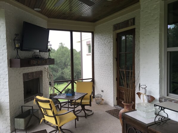 Screened back porch with TV and outdoor fireplace