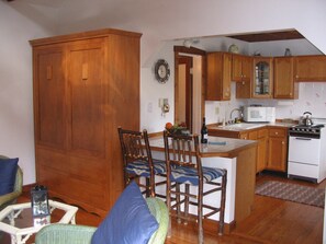 View into kitchen and entry into bathroom - with shower/tub, basin & toilet