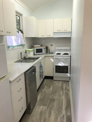 Galley kitchen with new flooring throughout cabin.