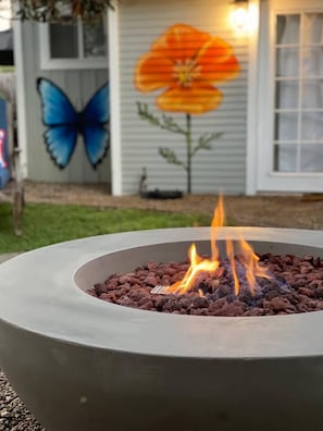 Shared outdoor fire pit and soaking tubs surrounded by local artist murals by @muchrock.