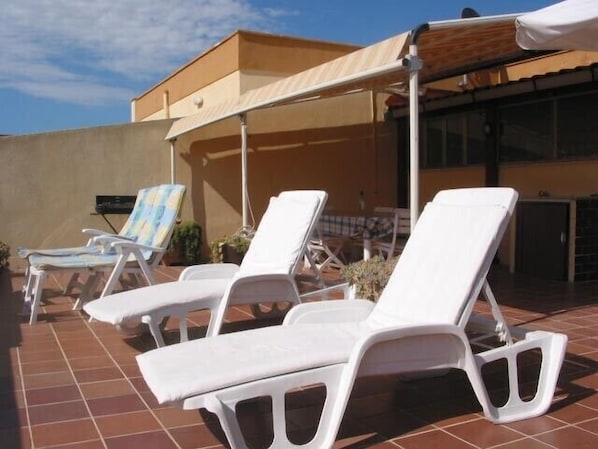 terrace at the same level of the kitchen, 8 long chairs, table, barbecue 