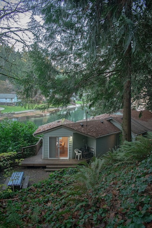 Overlooking back yard of cottage from parking area at dusk.