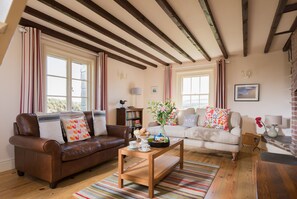 Main sitting room with a log burning stove and cinema sound large tv.