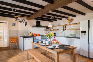 Farmhouse kitchen with vintage floorboards and oak beamed ceiling.