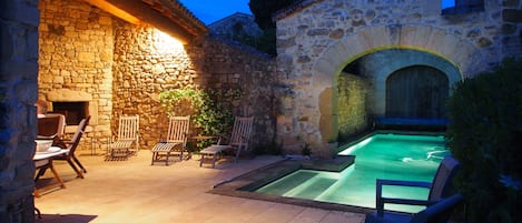 Pool house and pool at dusk.