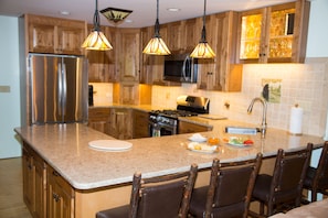 Large modern kitchen with latest appliances and quartz counter tops.