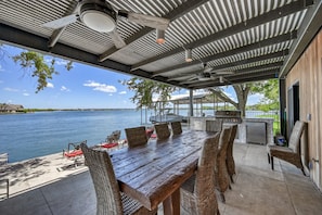 Covered porch with large dining table and build in grill.


