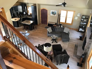 View of living room and kitchen from loft with king bed.