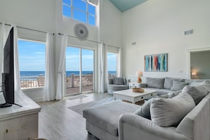 Large picture frame windows overlooking the large deck and ocean