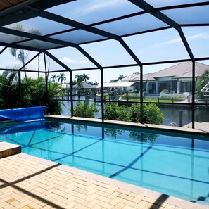 Large solar-heated pool and fountain with screened lanai and big canal view.