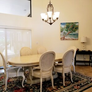 Dining room with view of outdoor living space, pool, and canal