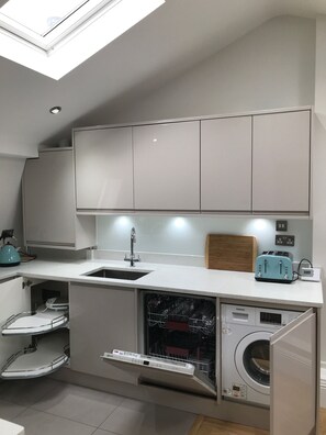 Cashmere gloss handle-less kitchen doors hide integrated appliances