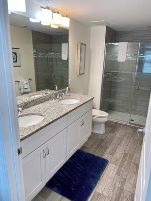 Spa-like en-suite bathroom connected to primary bedroom with king bed