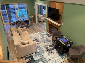 living area with cozy electric fireplace and arcade gaming table