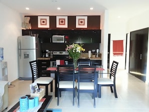 Dining room area and fully equipped kitchen with all utensils for cooking.