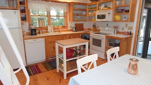 View of the kitchen, dining area, screened entrance, and exterior deck.