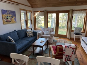 Living room with new couch and French doors to the clearing by the cove.