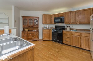 Large kitchen with gas range, and microwave. 