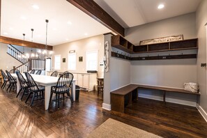 Large foyer with lots of storage and hooks overlooking the large dining table