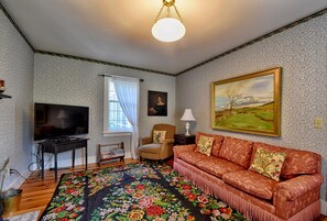 Two sofas provide comfortable seating.  The wallpaper design dates from c.1840. 