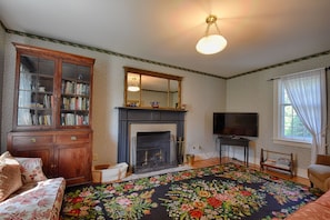 The sitting room combines historic atmosphere with modern comfort, including TV.