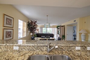 kitchen looking out into dining area, living room and lanai.