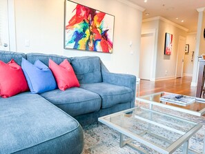 Relax in style with our plush sectional sofa, accented by vibrant pillows and bold modern artwork—creating a cozy, colorful retreat just minutes from Portland’s top spots.