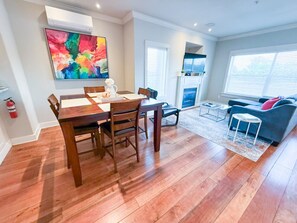 Bright, open, and artfully curated—this vibrant dining and living area features bold new canvas artwork and floods of natural light, offering the perfect backdrop for memorable meals and cozy nights in.