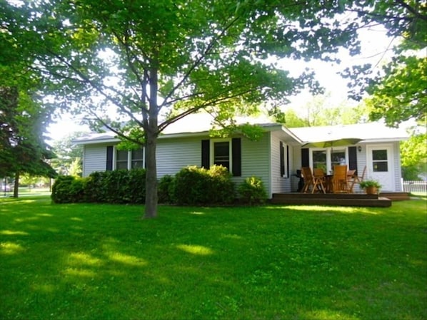 Your vacation home with expansive back yard, a wooden deck with furniture/grill.