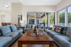 Floor-to-ceiling glass doors flood the space with natural light.