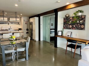 From front door toward kitchen, small bedroom behind glass door.