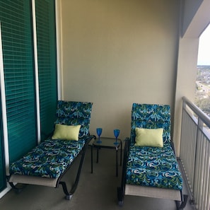 Two chaise lounge chairs facing beach and ocean