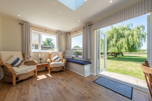 Tanholt: The sun room with comfortable seating looking out into the garden