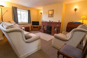 6 Clock Row, Thornham: Sitting room with open fire