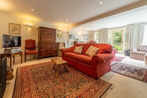 Saxon Shore Cottage, Burnham Deepdale: Sitting room with french doors leading into the garden