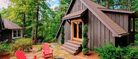 Exterior of the carriage house with firepit and 4 adirondack chairs for enjoying the large, wooded back yard.