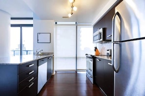 Modern kitchen with stone counter tops and stainless steel appliances