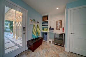 Walk into a newly built mud room with exterior access door to an outdoor shower