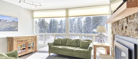 Living Area - Large picture windows, natural lighting, fireplace, and access to the private balcony.