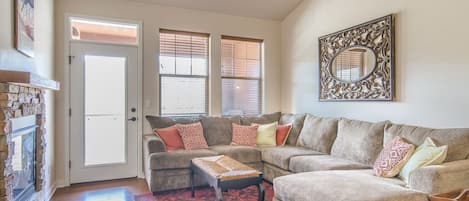 Living Area - Large sectional with chaise lounge, fireplace, flat screen TV, and access to private balcony.