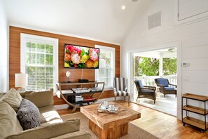 Gorgeous living room w/ vaulted ceilings, TV, and access to balc