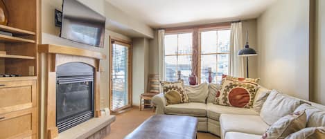 Living Area - Sectional sofa with Queen size sofa sleeper. Private balcony access, flat screen TV, and fireplace.