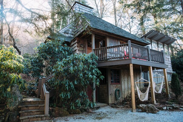 Exterior with cedar shake siding, stone, stairs, moss lawn, and beautiful rhododendron groves.