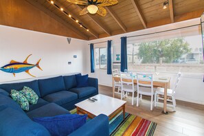 The living room has a comfy L-shaped sofa, perfect for lounging and watching the 43" Smart Fire TV. Enjoy the cool A/C and a peekaboo view of the bay! 