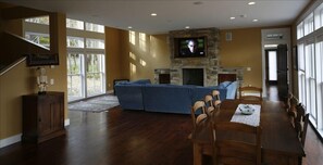 Living/Dining room with wood fireplace,flat screen tv, and entertainment center.