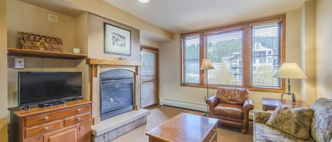 Living Area - Queen size sofa sleeper, gas fireplace, access to private balcony, and flat screen TV.