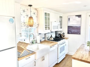 Light and bright kitchen with butcher block top island.