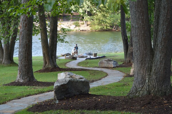 Stone walkway to the fire pit with nighttime tree mounted lighting