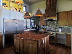 Kitchen with copper range hood built by owner. Bluestar six burner gas stove